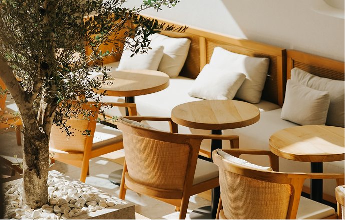 A terrace of tables under an olive tree