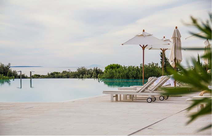 Loungers and parasols by an infinity pool